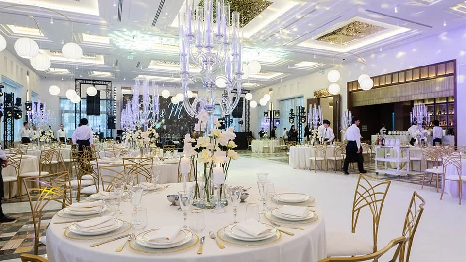 Grand Hall под банкет: круглые столы, канделябры с белыми орхидеями, барная стойка и сцена со светом
